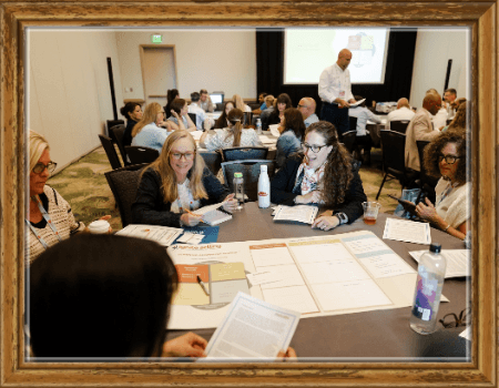 people at a workshop around a atable working on a common challenge
