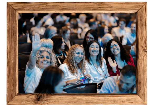 Smiling women at a geneeral session and waving at the camera